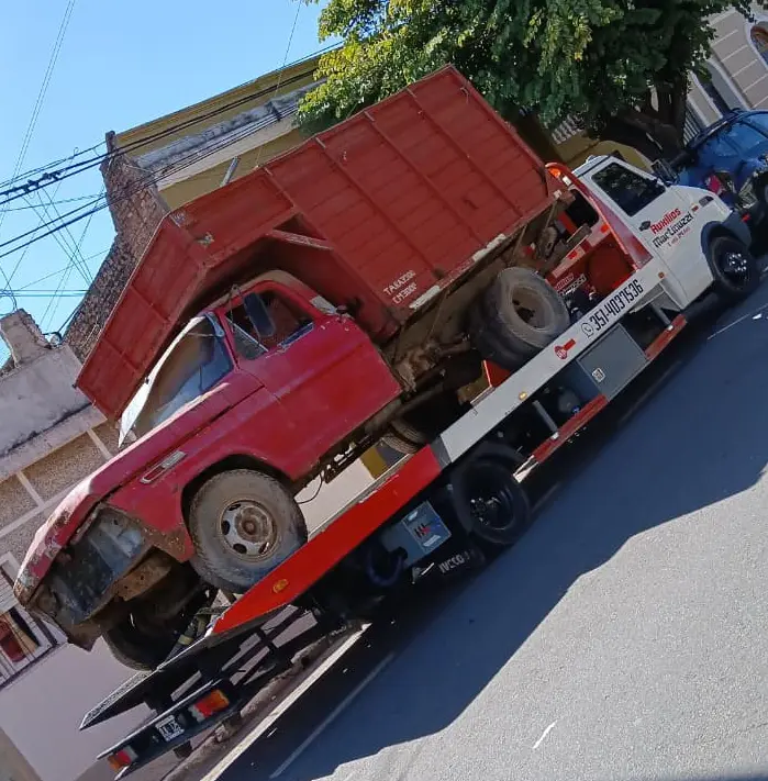Camión volcador trasladado en grúa plataforma